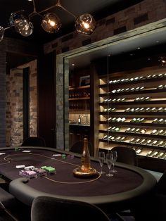 a table with wine bottles and glasses on it in front of a wall full of shelves