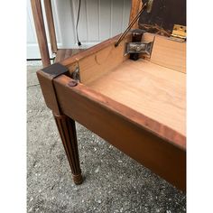 an old wooden table with a drawer on it's side and the door open