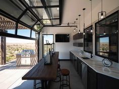 an image of a kitchen that is in the middle of someone's house with lots of windows