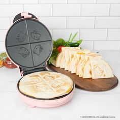 a waffle iron with slices of cheese in it on a counter next to some vegetables