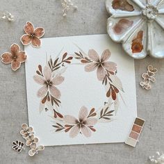 an image of some flowers on a table with paint swatches and other things around it