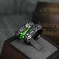 two rings with green inlays are on display