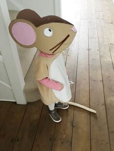 a child in a mouse costume standing next to a door