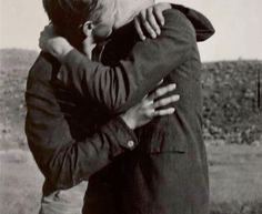 two men hugging each other in the middle of a field