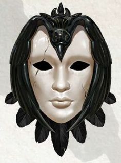 a white mask with black feathers on it