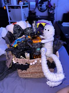 a stuffed animal in a basket on top of a bed next to bottles and other items