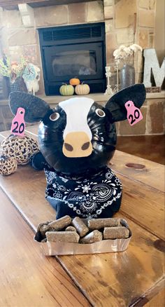 a cow statue sitting on top of a table in front of a fire place and fireplace