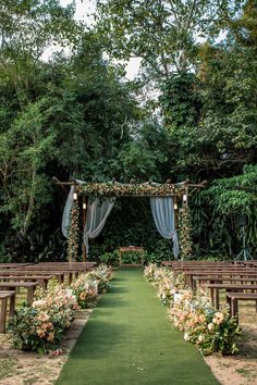 an outdoor ceremony setup with flowers and greenery