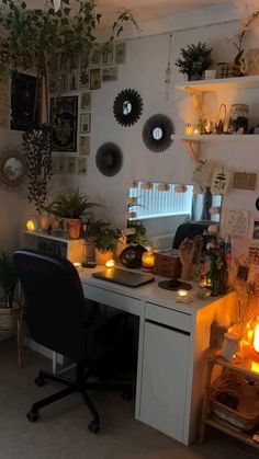 a desk with candles and pictures on the wall above it in a home office area