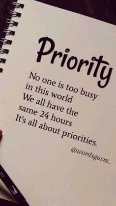 a hand holding a pen over a notebook with the words priority written on it,