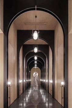 a long hallway with marble floors and lights hanging from the ceiling in an elegant building