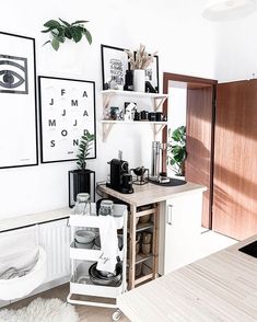 a kitchen with white walls and lots of pictures on the wall, including an eye print