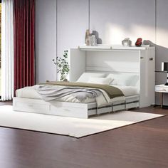 a white bed sitting on top of a hard wood floor next to a wall mounted tv