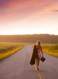 a woman walking down the middle of a road with her purse on one side and an open jacket on the other