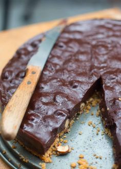 there is a chocolate cake on the plate with a wooden spoon in front of it