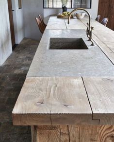 a kitchen counter made out of wooden planks with a sink and faucet