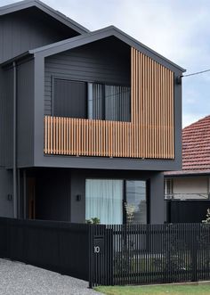 two houses with wooden balconies on the top and bottom floors, one is black