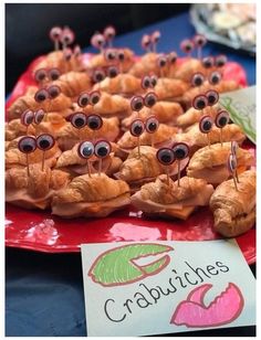 some croissants with googly eyes on them sitting on a red plate