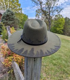 This hand burnt olive green wide brim fedora makes a perfect addition to any nature lover's wardrobe. I burnt pine trees on the back brim of the hat. Around the entire crown of the hat I intricately burned and shaded mountains and pine trees by hand with a pyrography machine. The design is original and completely free-handed. For a finishing touch, I added faux stitch marks on the crown and brim of the hat. The hat has a faux leather black belt hat band. Hat Materials: polyester/cotton Hat circu Burned Hat Mountains, Rustic Brimmed Felt Hat For Outdoor, Rustic Wide Brim Hat For Outdoor, Rustic Outdoor Brimmed Felt Hat, Rustic Flat Brim Felt Hat For Outdoor, Rustic Felt Hat With Flat Brim For Outdoor, Bohemian Short Brim Felt Hat For Outdoor, Bohemian Flat Brim Felt Hat For Outdoor, Bohemian Style Flat Brim Felt Hat For Outdoor