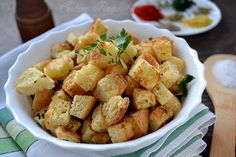 a white bowl filled with croutons on top of a table