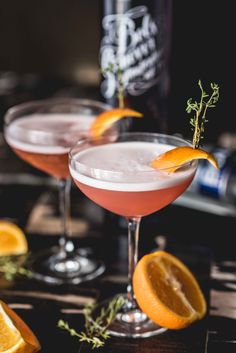 two martinis with orange slices and garnish on the rim