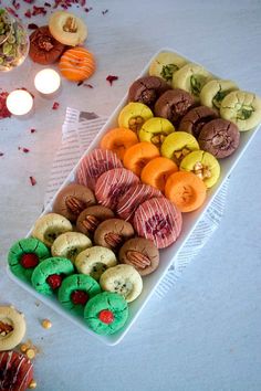 a tray filled with lots of different types of donuts next to candles and confetti