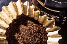 a bowl filled with brown powder next to a blender on top of a table