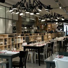 an empty restaurant with tables and chairs in front of the shelves filled with wine bottles