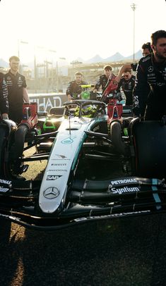 a group of men standing around a race car