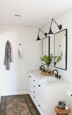 a white bathroom with two sinks and mirrors on the wall next to a rug that says instagram san diego, california