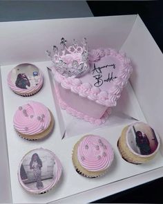 a box filled with cupcakes covered in pink frosting and topped with a tiara