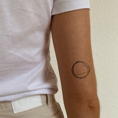 a person with a small tattoo on their left arm and the other arm behind him