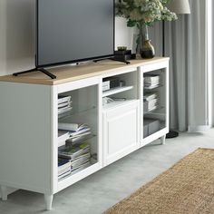 a flat screen tv sitting on top of a white entertainment center