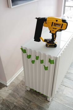 a cordless driller on top of a radiator cover in a room