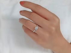 a woman's hand with a diamond ring on it