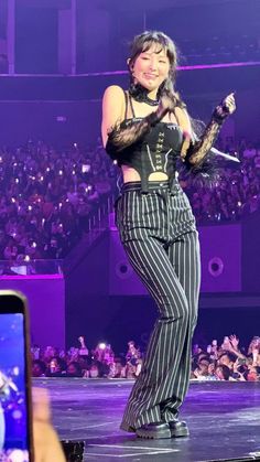 a woman in striped pants holding a microphone