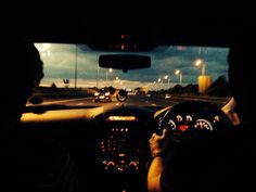 the view from inside a car at night, as it is driving down the road