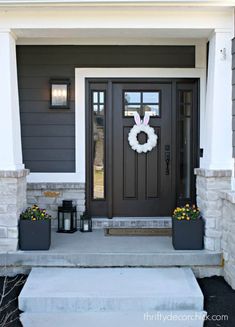 the front door is decorated with wreaths and lanterns