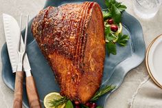 a large piece of meat sitting on top of a blue plate next to silverware