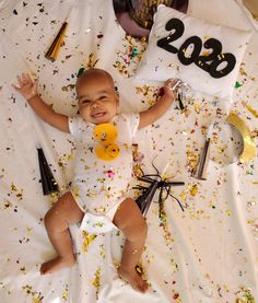 a baby laying on top of a bed with confetti all over it's body