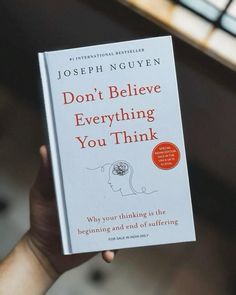 a person holding up a book with the title don't believe everything you think