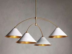 three white and gold lights hanging from a ceiling fixture