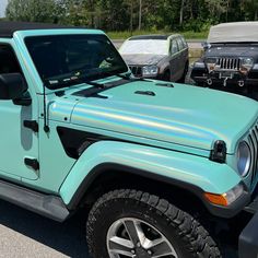 a blue jeep parked in a parking lot next to other cars