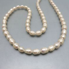 This is one lovely vintage real fresh water pearl necklace.  The pearls are barrel shaped in size and measure approximately 3/8ths inches long by 1/4 inch wide.  They are lustrous and fairly uniform with the color of cream. Every pearl is perfect with no loss of the nacre. The length of the necklace is 21  inches and they close with a real pearl decorated silvertone metal box style Interlocking clasp.  This is a lovely length for most women. These are truly classic in excellent condition.   We will send these to you in a lovely gift box for easy gift giving. IF you like vintage costume jewelry, old Mexican or Native American silver jewelry, bolo ties and western accessories, kindly check out my Etsy store at www.etsy.com/shop/PANDPF Classic Cream Pearl Chain Necklace, Classic Cream Pearl Necklace With Pearl Charm, Fresh Water Pearl Necklace, Water Pearl Necklace, Pearl Clasp, Western Accessories, Bolo Ties, Fresh Water Pearl, Real Pearls