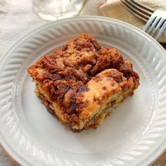 a white plate topped with two pieces of cake next to a fork and glass cup