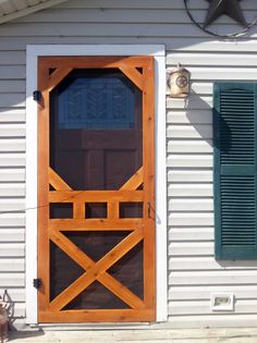 a wooden door on the side of a white house