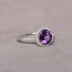 This is a 7mm natural amethyst birthstone ring set in solid sterling silver and with rhodium plated. The ring features a clear round faceted natural amethyst and lots of tiny zircon around of the main stone. If you want other size, please contact me to order and it will take 7-10 days to finish. The item is sent in a beautiful gift box You can realize more lovely stuff clicking the link https://www.etsy.com/shop/knightjewelry?refshopsection_shophome_leftnav Classic Amethyst Birthstone Ring In White Gold, Classic Amethyst Birthstone Promise Ring, Classic Round Gemstones With Center Stone, Classic Amethyst Crystal Ring For Anniversary, Sterling Silver Round Cut Gemstones For Anniversary, Classic Amethyst Ring With Cubic Zirconia For Gift, Classic Amethyst Cubic Zirconia Promise Ring, Classic Cubic Zirconia Amethyst Ring For Gift, Elegant Sterling Silver Amethyst Birthstone Ring