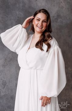 a woman in a white dress posing for a photo