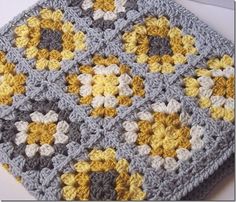 a crocheted square with yellow and gray flowers