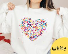 This fabulous heart-shaped sweatshirt makes a standout piece in your wardrobe. The stunning color combination enhances its visual appeal, making a bold statement that radiates positivity. The heart motif isn't just a graphic; it's a celebration of love, self-expression and joy. *Product Details* *crewneck style *professional printed *soft and cozy *no itchy side seam *unisex sweater *Materials* *50% Cotton 50% Polyester- a perfect combination of comfort and durability  *Sizing and Colors* *please refer to sizing and color charts in the images *runs true to size *size up for an oversized sweater look  *Care Instructions* *turn inside out and machine wash cold on delicate cycle *avoid dry cleaning, bleaching, or directly ironing the garment *Processing and Shipping Times* *Please allow 2-5 b White Long Sleeve Sweater For Valentine's Day, White Sweater For Valentine's Day, Valentine's Day Gift Sweatshirt, White Crew Neck Sweatshirt For Gift, White Crew Neck Sweatshirt As Gift, Casual Heart Graphic Sweatshirt Gift, Valentine's Day Gift Cotton Sweatshirt, Valentine's Day Cotton Sweatshirt Gift, Long Sleeve Sweatshirt For Mother's Day Gift